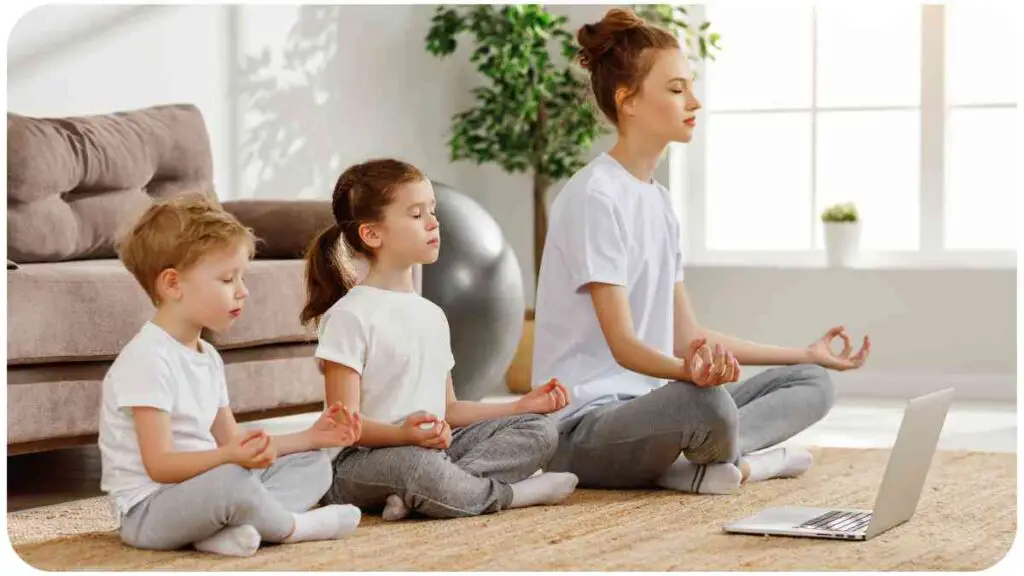 a person and two children meditating in front of a laptop