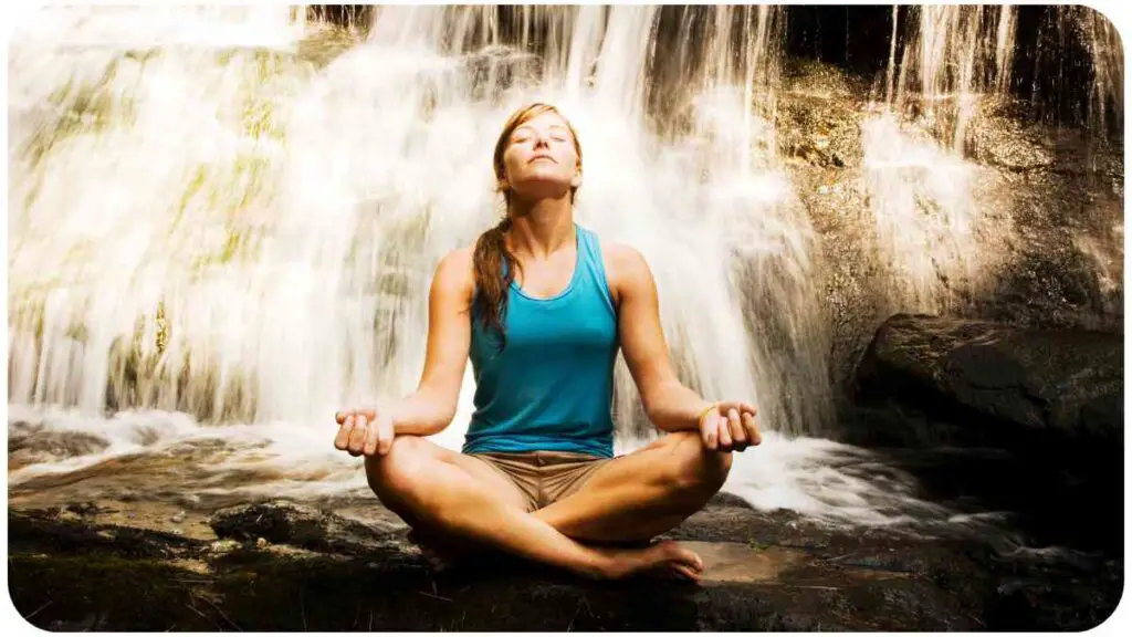 a person meditating in front of a waterfall