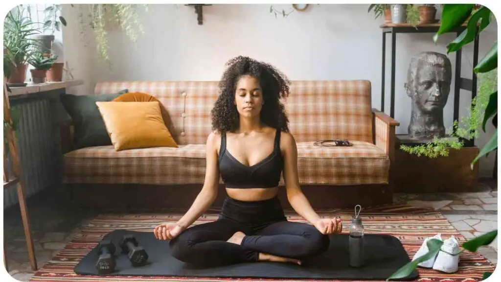 a person meditating on a yoga mat in front of a couch