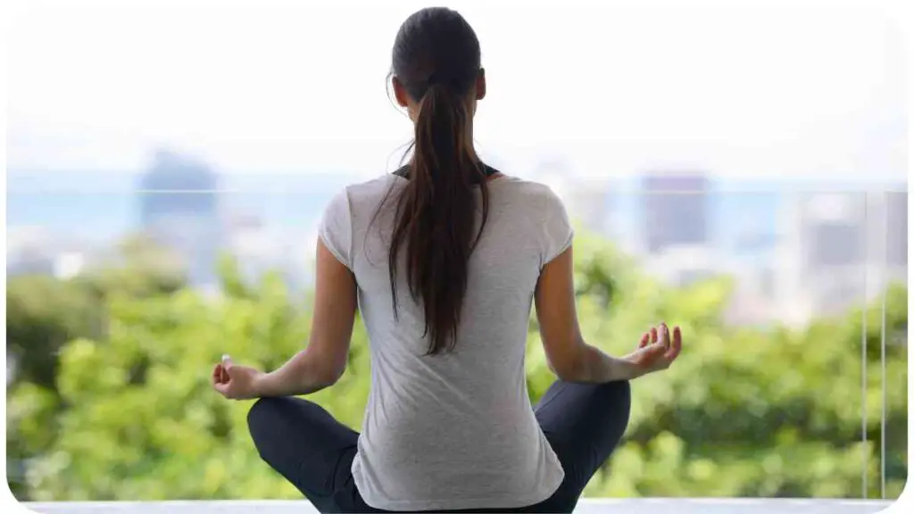 a person is sitting in a lotus position with their back to the camera