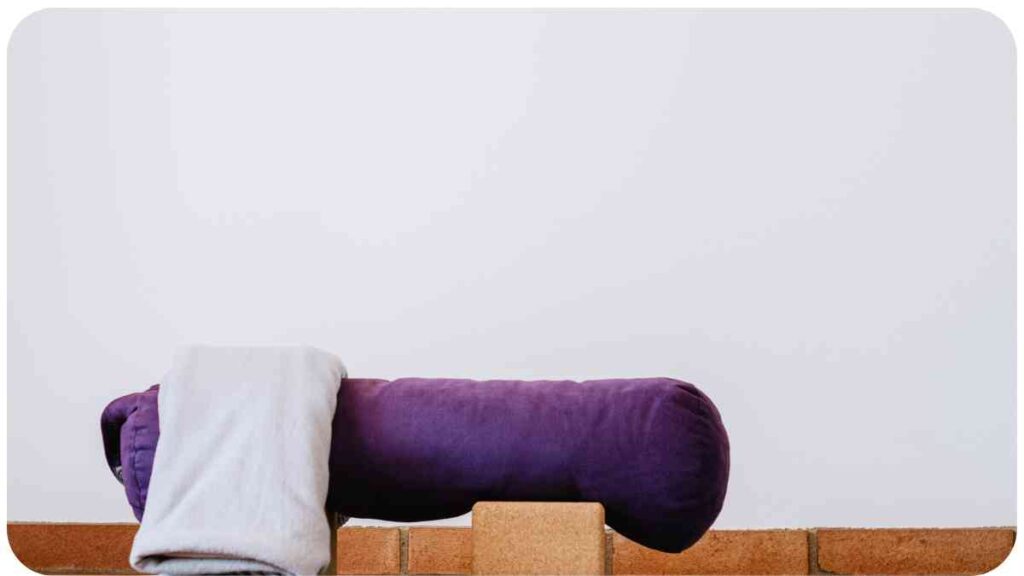 a purple pillow and blanket sitting on top of a wooden block