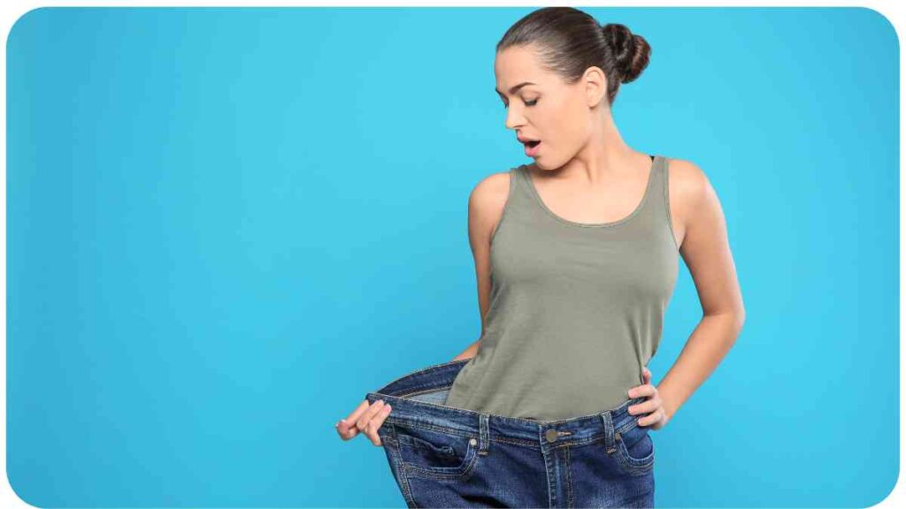 a person holding up their jeans on a blue background