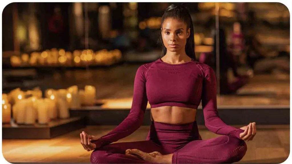 a person sitting in a yoga pose with candles in the background