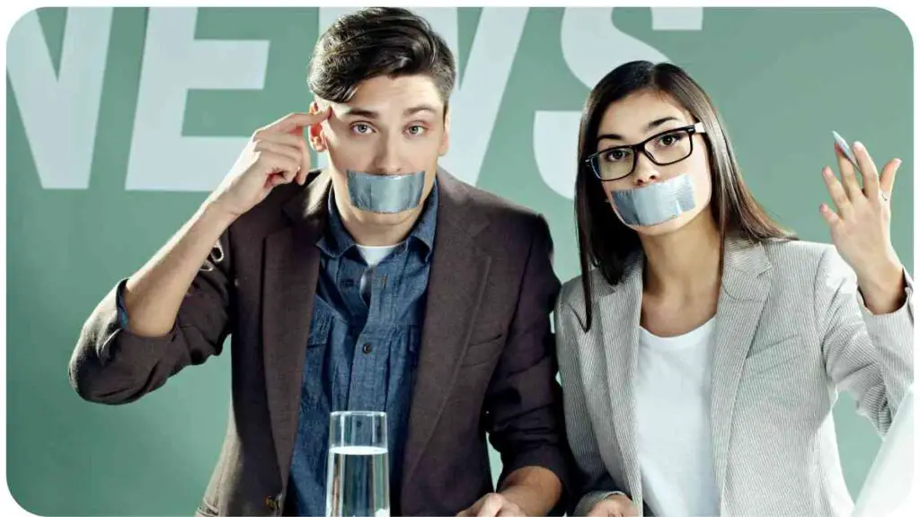 two people with tape over their mouths in front of a news sign